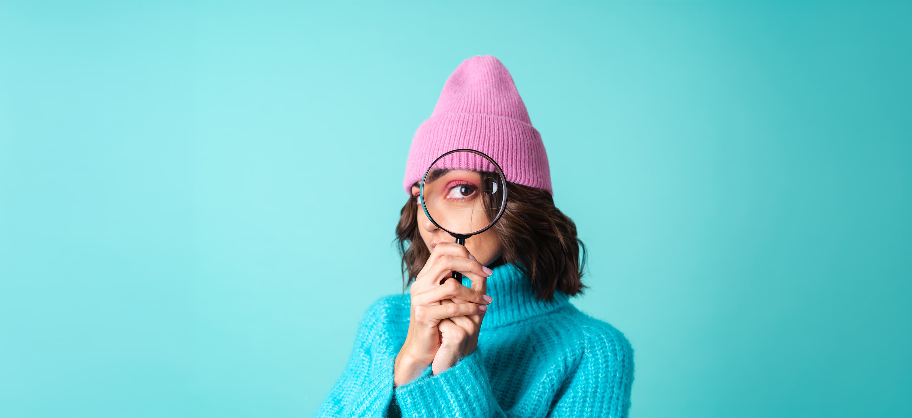 Woman looking through a magnifying glass
